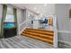 Open-concept living room featuring hardwood floors, an aquarium, and white stairs at 6932 Dalehollow Dr, Lithonia, GA 30058