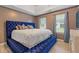 This main bedroom boasts an expansive blue tufted king bed with a tray ceiling and soft natural light at 6932 Dalehollow Dr, Lithonia, GA 30058