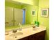 Bright bathroom with double sinks, mirror, wooden cabinets, framed art and fun wallpaper at 7550 Star Magnolia, Lithonia, GA 30058
