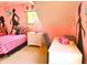 Large bedroom featuring a built in desk and vanity plus two stylish pink and black beds at 7550 Star Magnolia, Lithonia, GA 30058