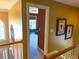 Upstairs hallway featuring wood railing with views to a sitting room and artwork at 7550 Star Magnolia, Lithonia, GA 30058