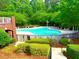 Community pool area surrounded by lush greenery offers residents a refreshing escape and a place to relax and socialize at 7550 Star Magnolia, Lithonia, GA 30058