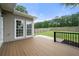 Backyard deck with wood flooring, a black metal railing, and a grassy area at 1130 Lochshyre Way, Lawrenceville, GA 30043