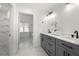Bathroom with double vanity sinks, gray cabinets, modern fixtures, and a separate dressing room at 1130 Lochshyre Way, Lawrenceville, GA 30043