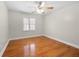Cozy bedroom with hardwood floors, a ceiling fan, and a large window at 1130 Lochshyre Way, Lawrenceville, GA 30043
