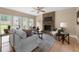 Cozy living room featuring a stone fireplace, hardwood floors, and a view of the backyard at 1130 Lochshyre Way, Lawrenceville, GA 30043