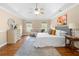 Spacious main bedroom featuring a tray ceiling, hardwood floors, and comfortable seating area at 1130 Lochshyre Way, Lawrenceville, GA 30043