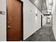 Modern condo hallway with metal ceiling, gray carpet, white walls, and dark wood doors at 130 Arizona Ne Ave # 104, Atlanta, GA 30307