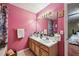 Bright pink bathroom with dual sinks, vanity, and modern fixtures offers style and convenience at 1358 Stoneleigh Way, Stone Mountain, GA 30088