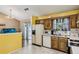 Bright kitchen with white appliances and cabinets adjacent to the dining area at 1358 Stoneleigh Way, Stone Mountain, GA 30088