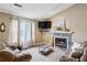 Comfortable living room includes a fireplace, a large window and neutral decor at 1358 Stoneleigh Way, Stone Mountain, GA 30088