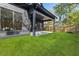 View of home's backyard featuring manicured lawn and covered patio with fan at 2032 Spink Nw St, Atlanta, GA 30318