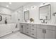 Modern bathroom with double vanity, separate tub, and glass enclosed shower with a marble surround at 2032 Spink Nw St, Atlanta, GA 30318