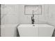 Soaking tub in a modern bathroom with a glass enclosed shower and marble surround at 2032 Spink Nw St, Atlanta, GA 30318