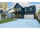 Charming two-story home boasts a dark blue exterior, dormer windows, and a spacious driveway at 2032 Spink Nw St, Atlanta, GA 30318