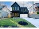 Inviting two-story home with a dark blue exterior, covered entry, and newly landscaped front yard at 2032 Spink Nw St, Atlanta, GA 30318