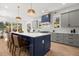 Modern kitchen boasts an island with seating, pendant lighting, gray cabinets, and hardwood floors at 2032 Spink Nw St, Atlanta, GA 30318
