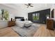 Luxurious main bedroom featuring a tray ceiling, accent wall, and large windows with a treed view at 2032 Spink Nw St, Atlanta, GA 30318