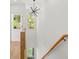 Open staircase with modern chandelier and natural wood railing, offering bright light from surrounding windows at 2032 Spink Nw St, Atlanta, GA 30318