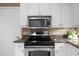 Kitchen featuring stainless steel oven and microwave, granite counters and white cabinets at 3334 Peachtree Ne Rd # 608, Atlanta, GA 30326