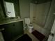 Standard bathroom featuring a toilet, a tub with a shower and a vanity with a dark green cabinet at 3832 Natalie Way, Ellenwood, GA 30294