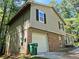 Exterior shot of a two-story home with siding, brick, an attached garage, and lots of surrounding trees at 3832 Natalie Way, Ellenwood, GA 30294