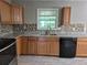 Modern kitchen with wood cabinets, granite countertops, stainless steel appliances, and bright natural light at 3832 Natalie Way, Ellenwood, GA 30294