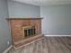 Living room with brick fireplace, neutral paint, and wood-look floors offers a cozy atmosphere at 3832 Natalie Way, Ellenwood, GA 30294