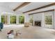 Bright, open living room with beamed ceilings, large windows, and a stone fireplace at 1176 Lullwater Ne Rd, Atlanta, GA 30307