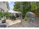 Backyard with patio seating area, gravel ground cover, and a greenhouse surrounded by trees at 268 Cottonwood Creek Cir, Canton, GA 30114