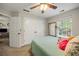 Cozy bedroom featuring a ceiling fan, double closet, and a window view of lush greenery at 268 Cottonwood Creek Cir, Canton, GA 30114