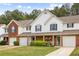 Inviting townhome exterior featuring brick accents, blue shutters, and a cozy covered porch with a beautiful garden at 268 Cottonwood Creek Cir, Canton, GA 30114