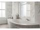 Close up of bathtub with mosaic tile, with marble walls, and window view at 2881 Peachtree Ne Rd # 2304, Atlanta, GA 30305
