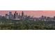 Stunning twilight skyline view with iconic Atlanta buildings and lush green tree canopy at 2881 Peachtree Ne Rd # 2304, Atlanta, GA 30305