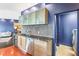 Kitchen wet bar features glass-front cabinets, stylish backsplash, stainless steel appliances, and adjacent laundry room at 2881 Peachtree Ne Rd # 2304, Atlanta, GA 30305