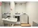 Functional laundry room includes a sink, mirror, and modern washer and dryer units at 3285 Long Iron Pl, Lawrenceville, GA 30044