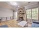 Cozy living room featuring a stone fireplace, wood-look floors, and large window at 3285 Long Iron Pl, Lawrenceville, GA 30044