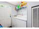 Functional laundry room with washer, dryer, storage shelf, and convenient exterior access at 101 Olympic Ct, Fayetteville, GA 30214