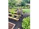 Beautiful backyard patio with lush landscaping, various trees in pots, and wooden benches at 287 West Wind Dr, Lilburn, GA 30047
