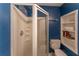 Bathroom featuring shower with glass door, toilet, and shelving with decor at 287 West Wind Dr, Lilburn, GA 30047