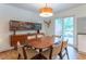 Dining room with stylish mid-century modern decor, including a display cabinet, a dining table and slider doors at 287 West Wind Dr, Lilburn, GA 30047