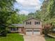 Charming split-level home with a two-car garage, red front door, and manicured lawn at 287 West Wind Dr, Lilburn, GA 30047