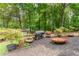 Landscaped backyard with a grill, fire pit, potted trees, and lush greenery at 287 West Wind Dr, Lilburn, GA 30047