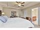 Comfortable main bedroom with tray ceilings, ceiling fan, and adjacent bathroom entry at 4181 Integrity Way, Powder Springs, GA 30127