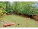 Spacious backyard with lush grass, mature trees, and a charming playset at 1582 E Bank Dr, Marietta, GA 30068