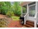 View of the backyard and screened-in porch with wooden steps down to the lawn at 1582 E Bank Dr, Marietta, GA 30068