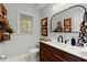 A powder room with a dark wood vanity, white countertop, decorative mirror and commode at 1582 E Bank Dr, Marietta, GA 30068