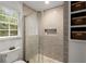 Bright bathroom with a glass enclosed shower featuring stylish tile work and built-in shelving for storage at 1582 E Bank Dr, Marietta, GA 30068