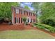 Charming two-story brick home with black shutters, a well-manicured lawn, and lush green trees at 1582 E Bank Dr, Marietta, GA 30068