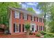 Attractive red brick home with black shutters and a white door, surrounded by mature trees at 1582 E Bank Dr, Marietta, GA 30068
